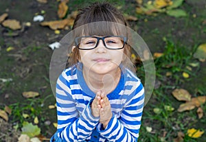 Kid whining asking to make her gift begging holding hands in pray pursing lips.