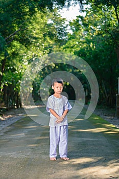 Kid on white clothing , practice walking Meditation in forest tr