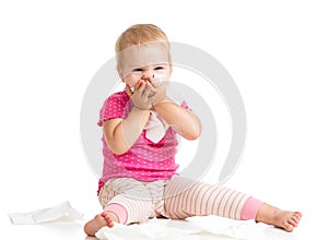 Kid wiping or cleaning nose with tissue on white
