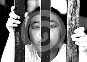 Kid with wood fence, feeling no freedom, black and white photography.