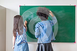 Kid write on chalk board. Back to school. Schoolchild in class. Happy kid writing green blackboard