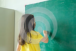 Kid write on chalk board. Back to school. Schoolchild in class. Happy kid writing green blackboard