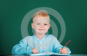 Kid writing in class. School child student learning in class, study english language at school.