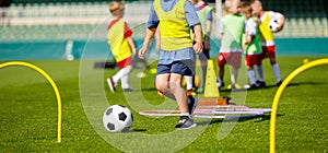 Kid Young Athletes Training with Football Equipment. Football Speed and Agility Training