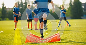 Kid Young Athletes Training with Football Equipment. Football Speed Training