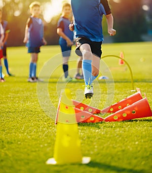 Kid Young Athletes Training with Football Equipment. Football Speed Training