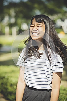 Kidding face of asian teenager showns forelock hair flowing by w