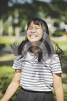 Kidding face of asian teenager showns forelock hair flowing by w photo