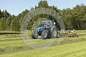 The kidding of shaken grass with blue tractor with