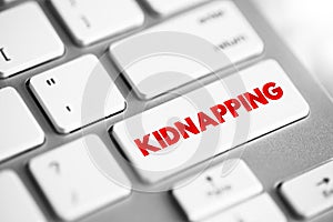 Kidnapping - unlawful confinement of a person against their will, text concept button on keyboard