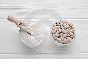 Kidney bean flour and seeds on white wooden table, flat lay