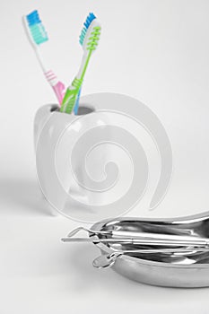 Kidney shaped tray with set of dentist`s tools on light background, closeup. Space for text