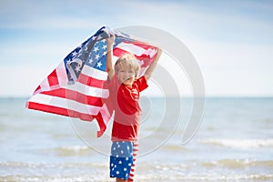 Kids with American flag on beach. 4th of July