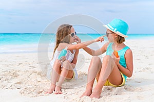 Kids applying sun cream to each other on the beach. The concept of protection from ultraviolet radiation