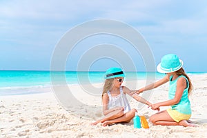 Kids applying sun cream to each other on the beach. The concept of protection from ultraviolet radiation