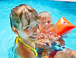 Kids with armbands in swimming pool.