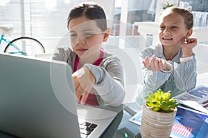 Kids as business executives discussing over laptop