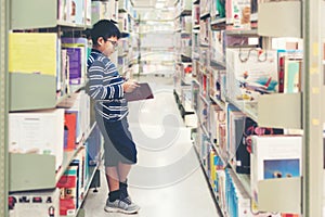 Kids asia boy reading books for education and go to school in library