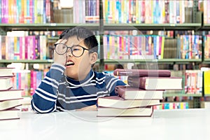 Kids asia boy reading books for education and go to school in library.