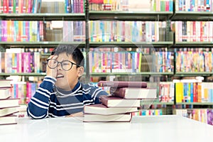 Kids asia boy reading books for education and go to school in library .