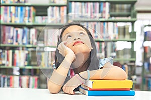 Kids asian beautiful girl reading books and thinking for education and go to school in library