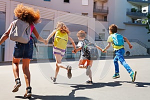 Kids with backpacks run to school