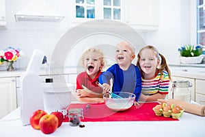 Kids baking a pie in white kitchen