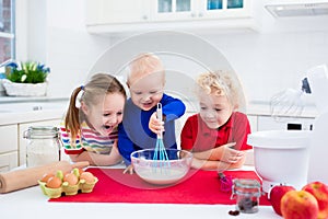 Kids baking a pie in white kitchen