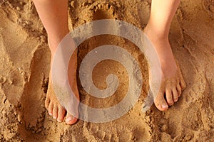 Kids bare feet on sand close up photo