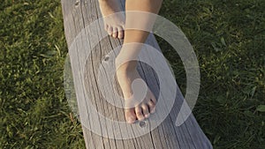 Kids bare feet walk on the wood log. Benefit of walking barefoot.