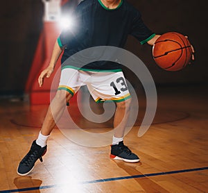 Kids Basketball Training. Young Basketball Player Dribble the Ball on the Wooden Court