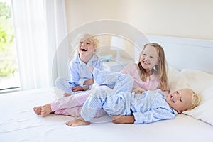 Kids in bed. Children in pajamas. Family bedroom.