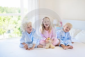 Kids in bed. Children in pajamas. Family bedroom.