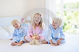 Kids in bed. Children in pajamas. Family bedroom.