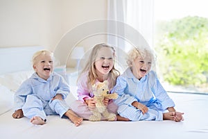 Kids in bed. Children in pajamas. Family bedroom.