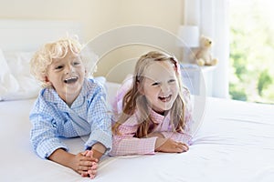 Kids in bed. Children in pajamas. Family bedroom.