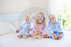 Kids in bed. Children in pajamas. Family bedroom