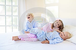 Kids in bed. Children in pajamas. Family bedroom