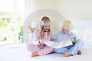 Kids in bed. Children in pajamas. Family bedroom. photo