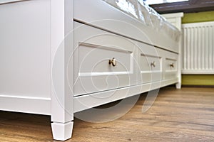 Kids bed with storage. Classic children`s furniture in white color close-up