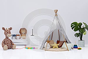 Kids bedroom with stuffed toy animals and play teepee.