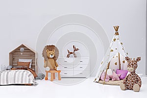 Kids bedroom with stuffed toy animals and play teepee.