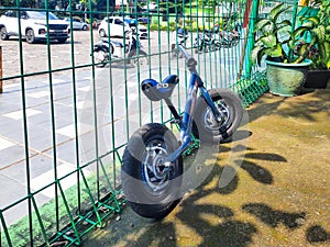 Kids bike leaning against fence