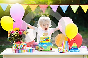 Kids birthday party. Child blowing out cake candle