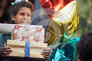 Kids birthday party . Little boy in birthday cap holding pile of birthday presents