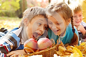 Kids biting autumnal apples