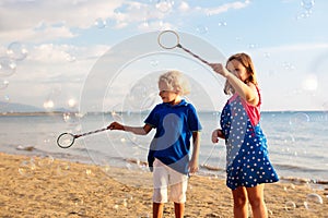 Kids blow bubble at beach. Child with bubbles