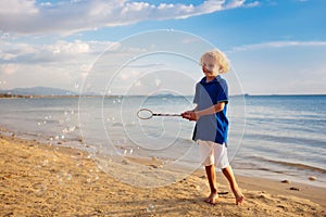 Kids blow bubble at beach. Child with bubbles