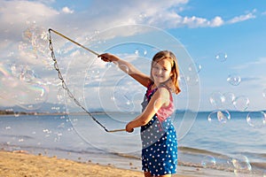 Kids blow bubble at beach. Child with bubbles