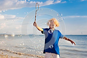 Kids blow bubble at beach. Child with bubbles